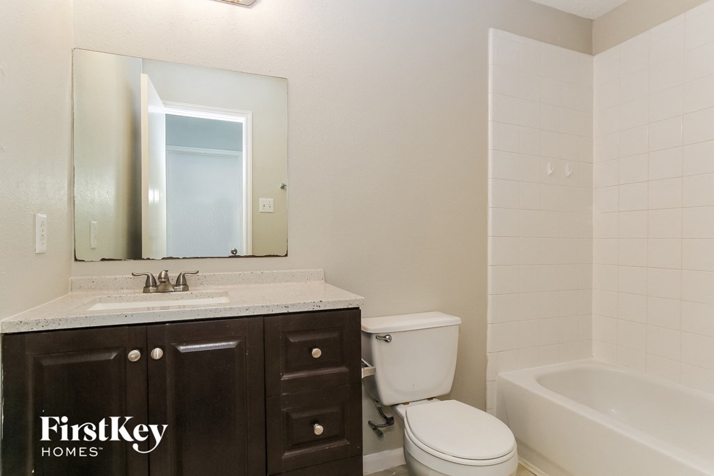 a bathroom with a toilet sink and mirror and a tub