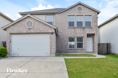 a brick house with a white garage door and a lawn