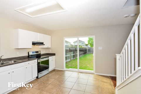 a kitchen with a sliding glass door to the backyard