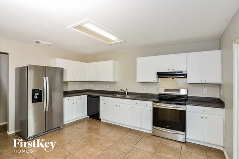 a kitchen with white cabinets and a stainless steel refrigerator