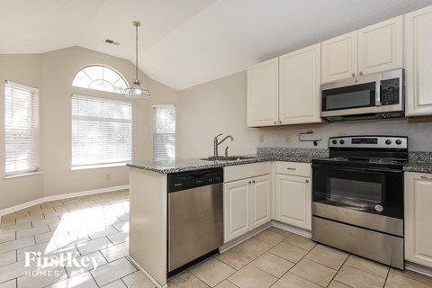 A kitchen with a stainless steel dishwasher and oven.