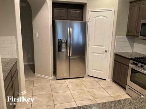 a kitchen with a stainless steel refrigerator and a door