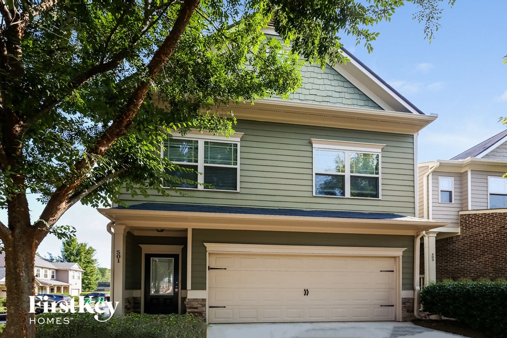 A two-story house with a garage is for sale.