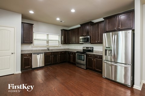 A kitchen with dark brown cabinets and stainless steel appliances.
