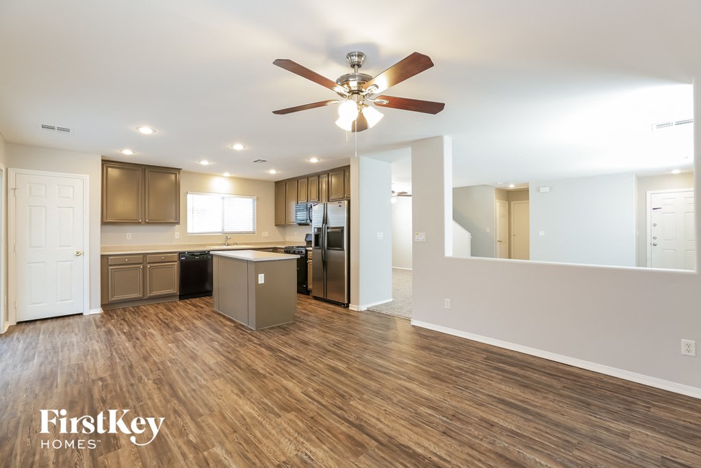 an open kitchen and living room with a ceiling fan