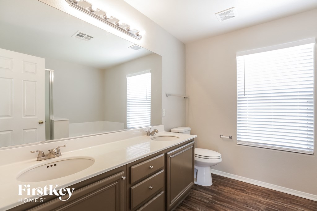 a bathroom with a large mirror and a toilet and a sink