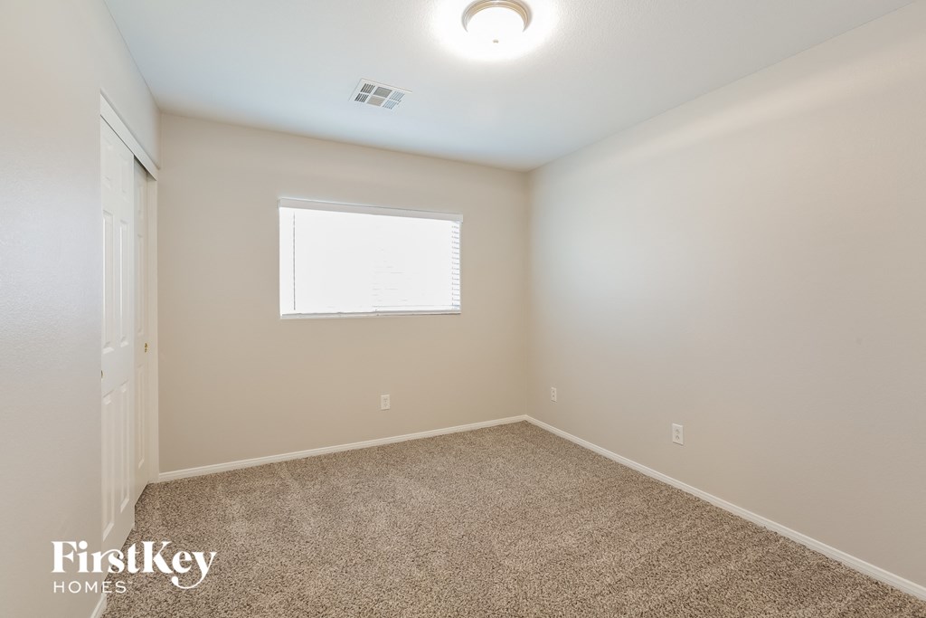 a spacious room with carpet and a window