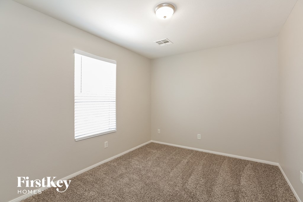 the upstairs bedroom has carpet and a large window