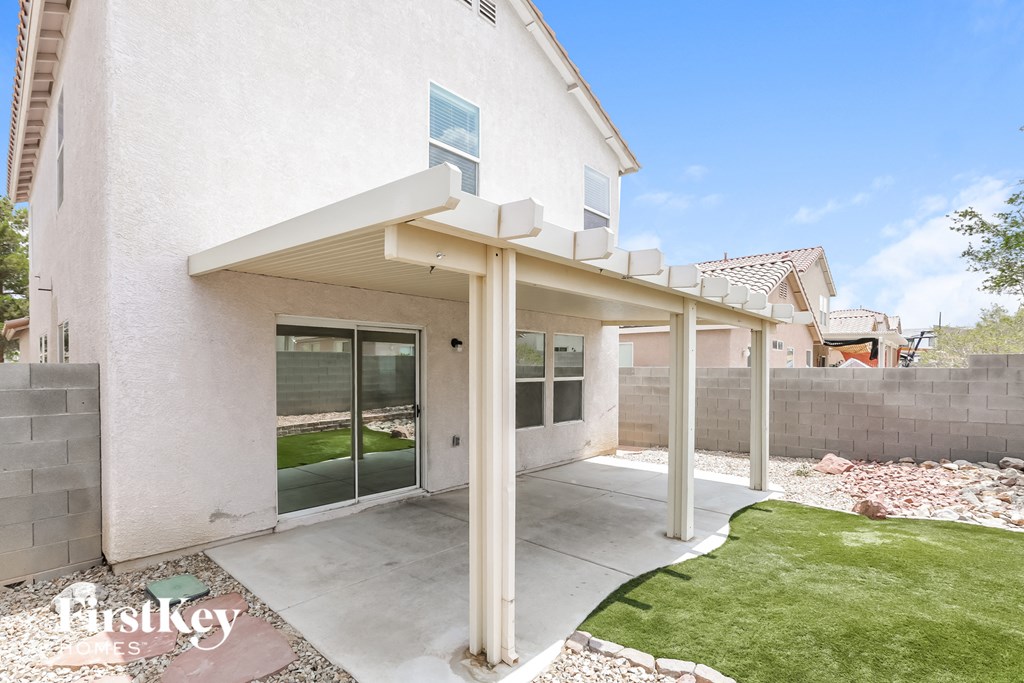 a covered patio in front of a white house