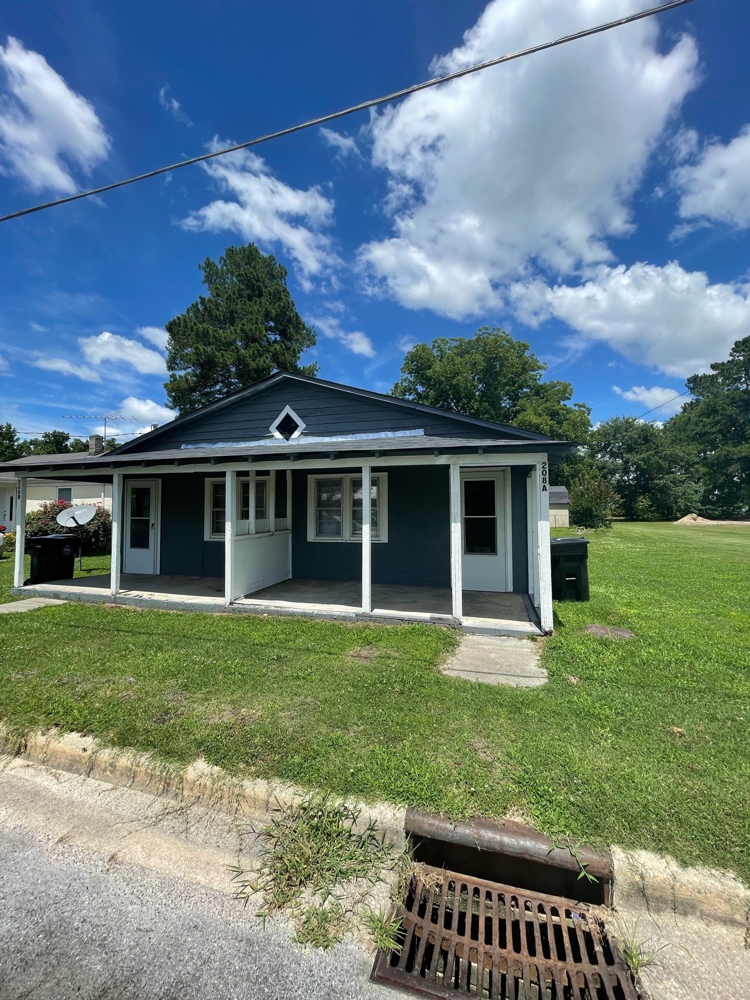 A small blue house with a porch and a white door.