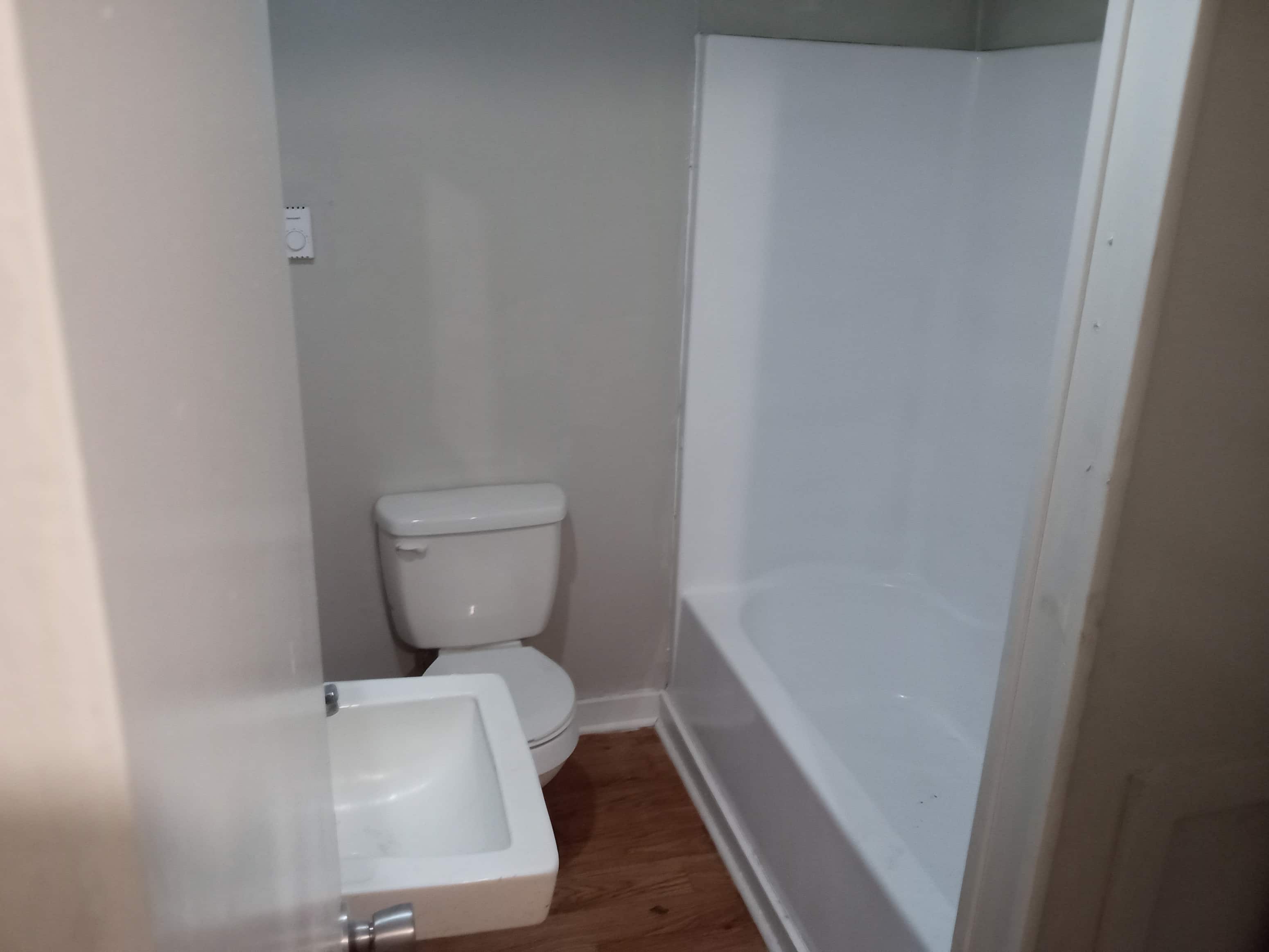 A white toilet and sink in a small bathroom.