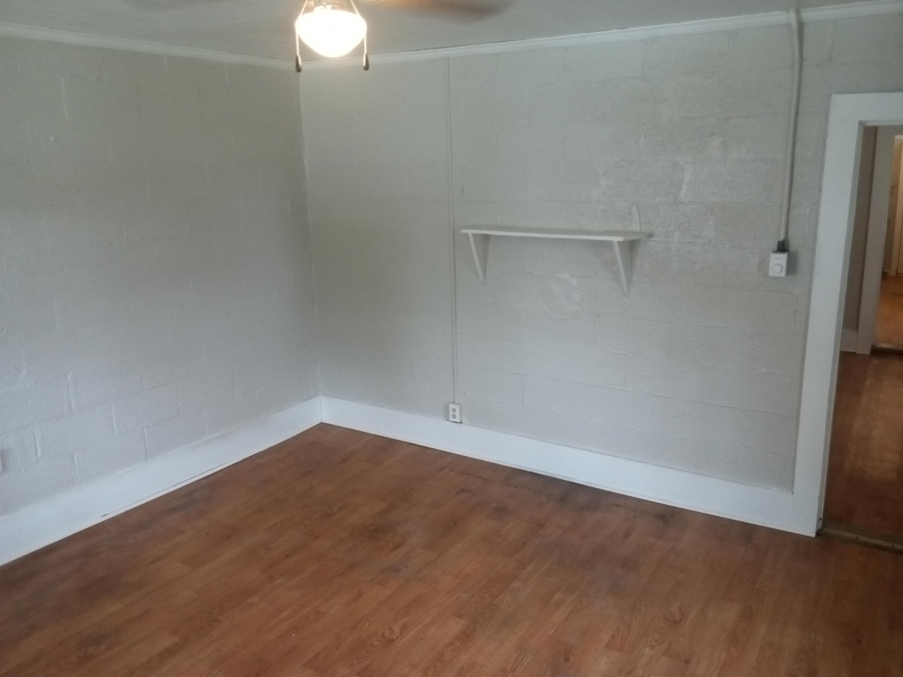 Empty room with wooden floor and white walls.