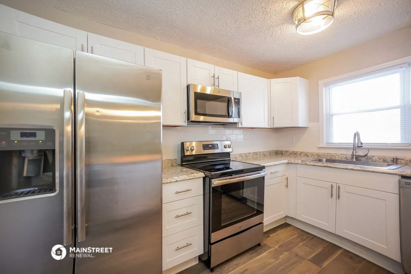 a kitchen with stainless steel appliances and white cabinets