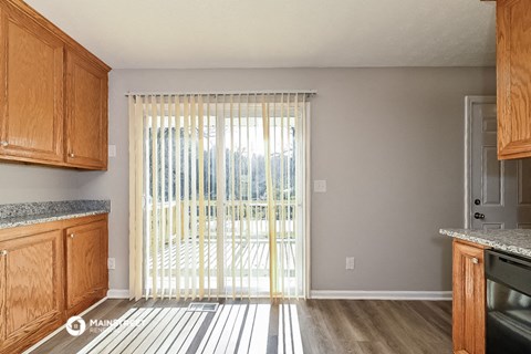 a kitchen with wooden cabinets and a sliding glass door