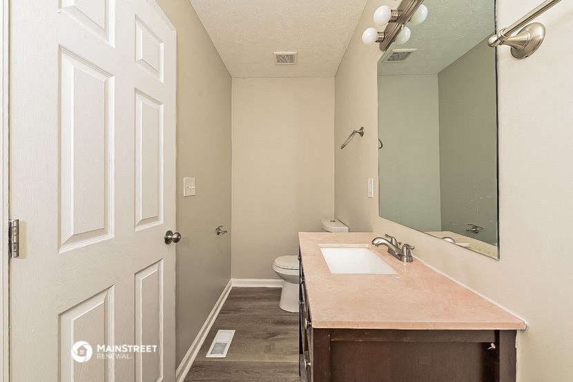 a bathroom with a sink and a toilet and a mirror