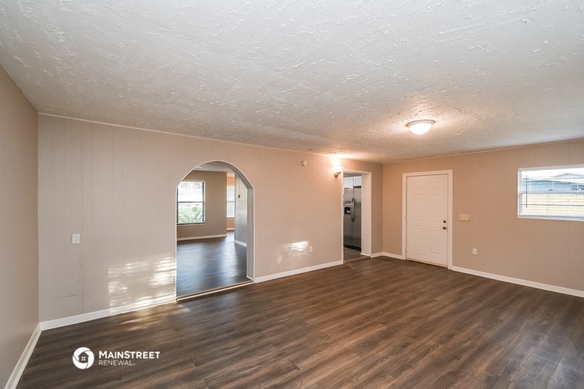 the living room and dining room of an empty house