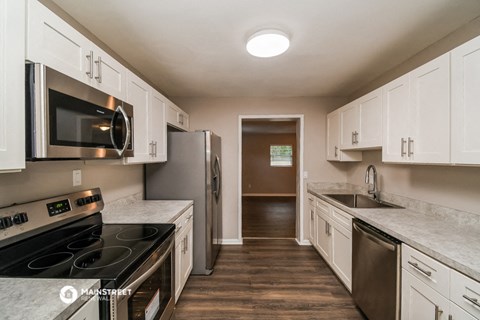 a kitchen with white cabinets and stainless steel appliances