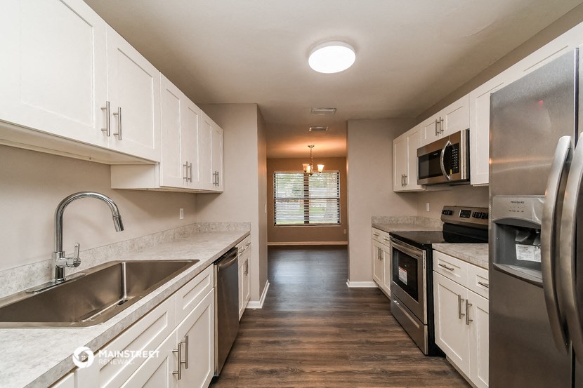 a kitchen with white cabinets and stainless steel appliances