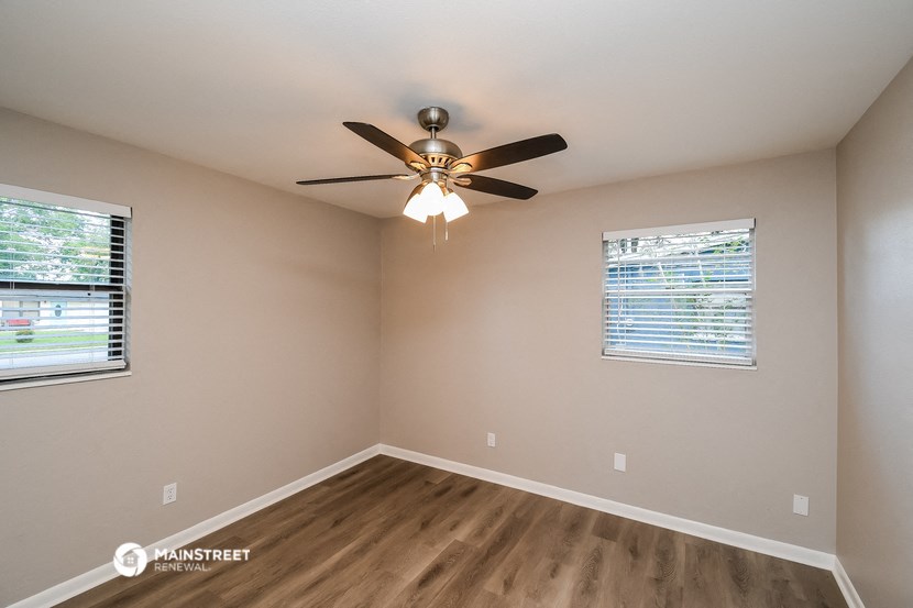 the bedroom has a ceiling fan and a window