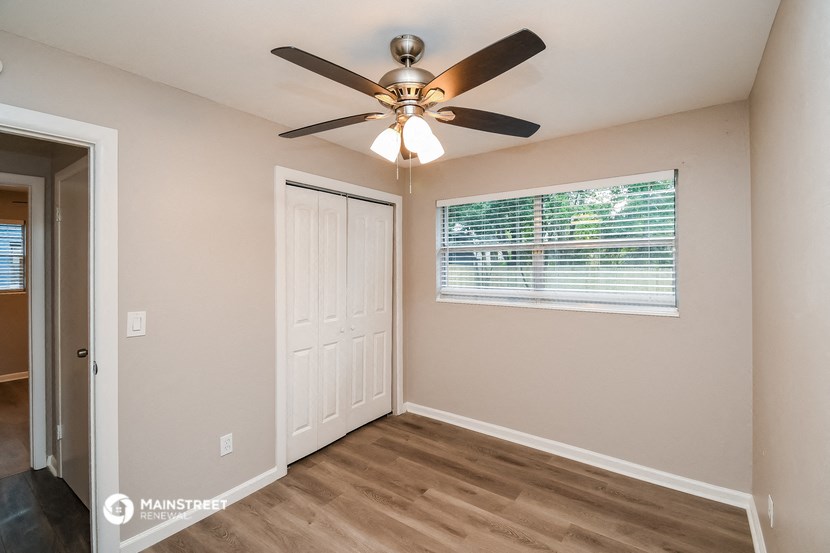 the living room of a home with a ceiling fan and a window