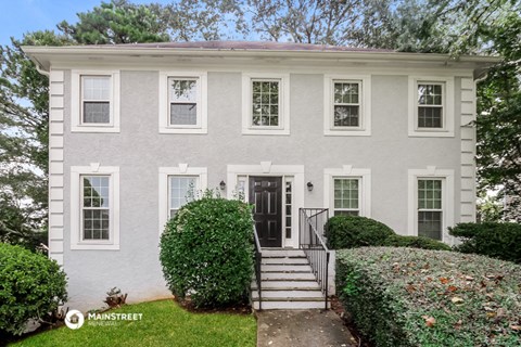 a white house with a black door and stairs