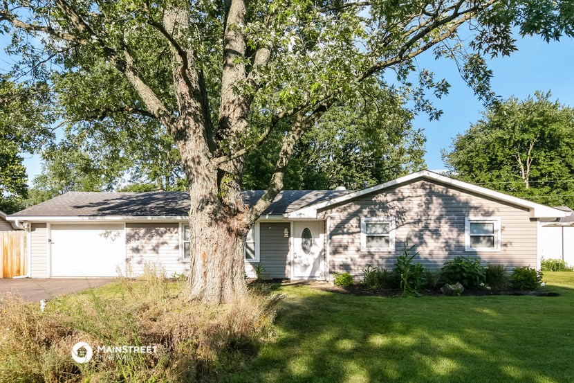 a white house with a large tree in front of it