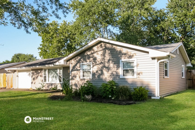 the exterior of a home with a lawn and trees