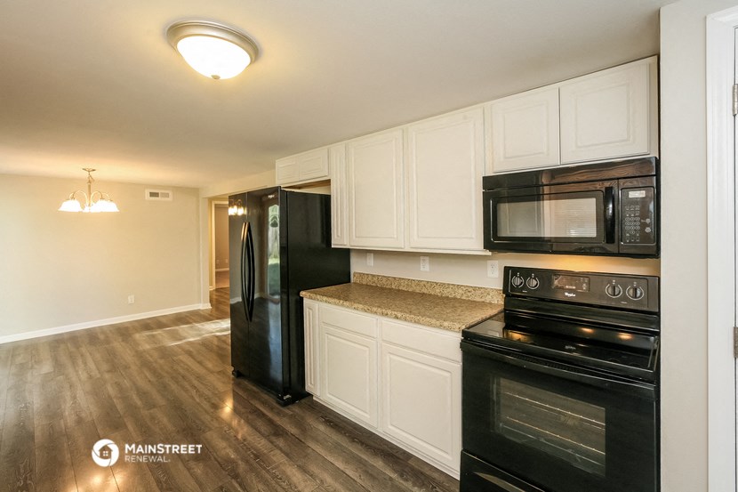 a kitchen with black appliances and white cabinets