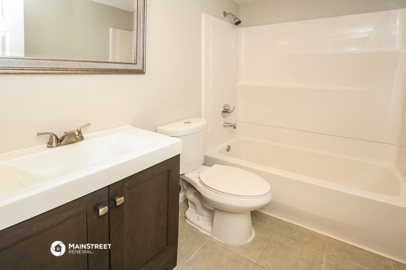 a bathroom with a toilet and a sink and a bath tub