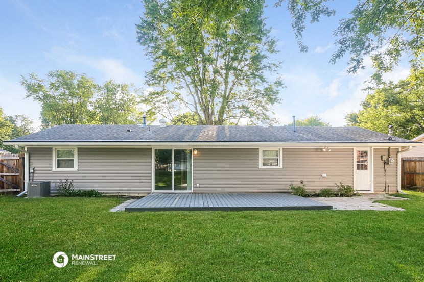 the front of a house with a yard and a deck