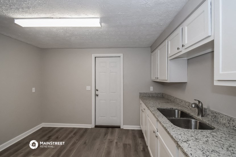 the kitchen of our studio apartment atrium with granite countertops and white cabinets