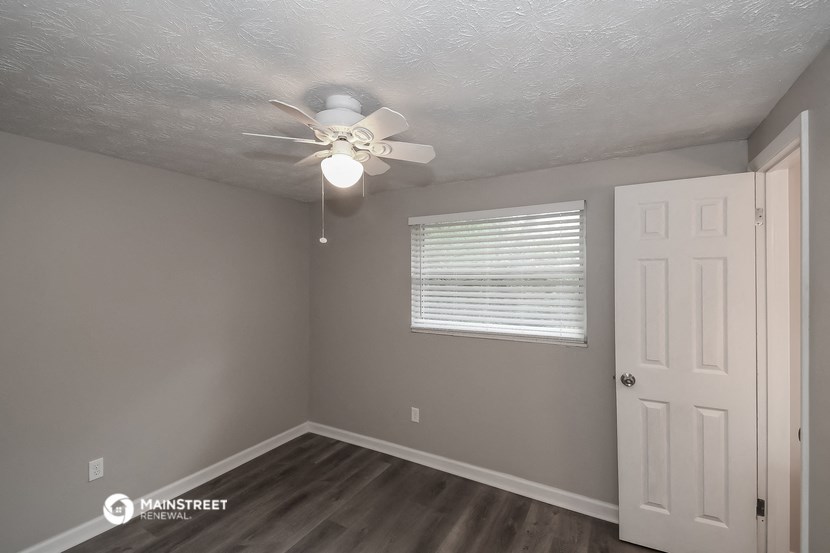 the interior of a bedroom with a ceiling fan and a door