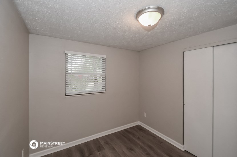 the interior of an empty room with a window and a closet