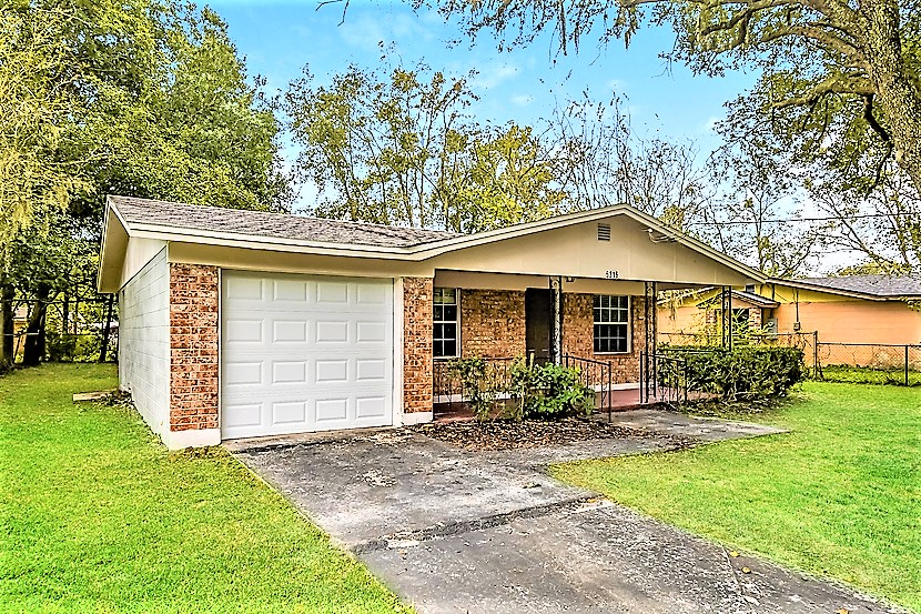a small brick house with a white garage door