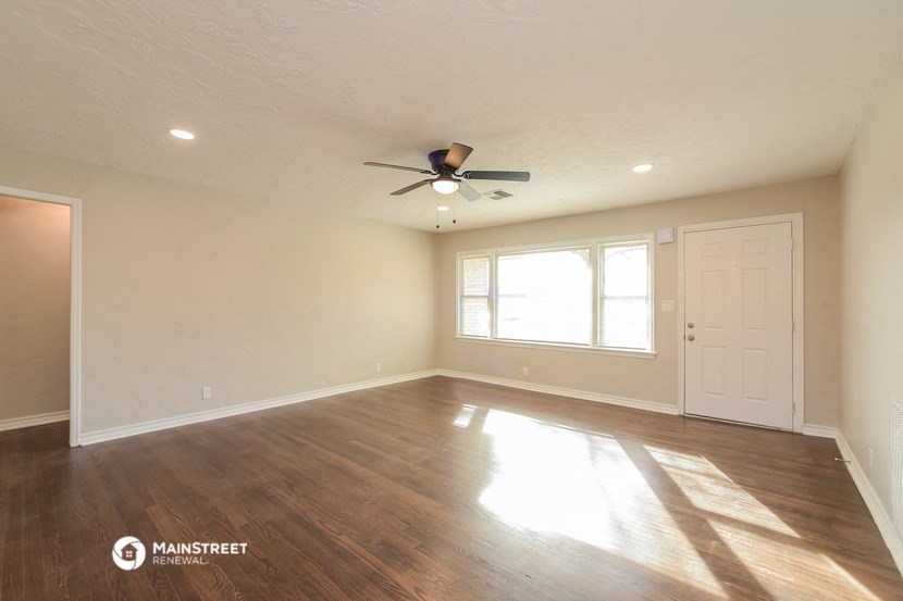 the living room of an empty house with a ceiling fan