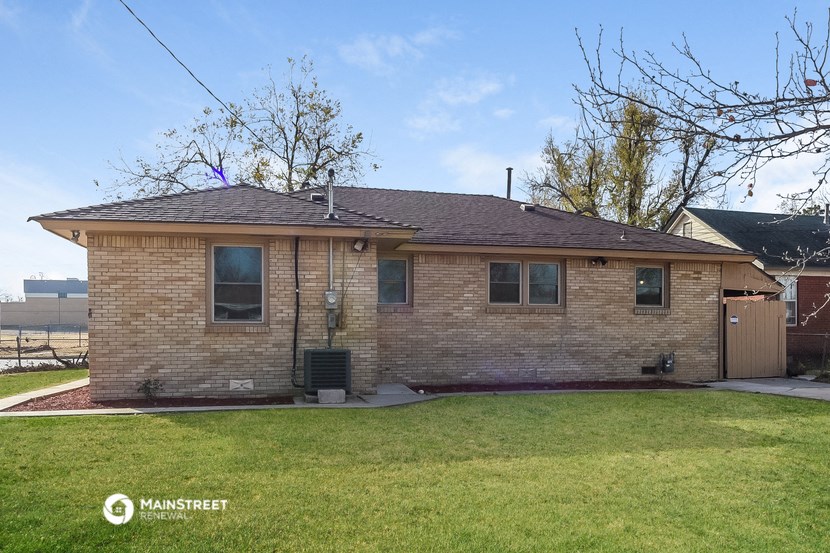 a small brick house with a yard and grass