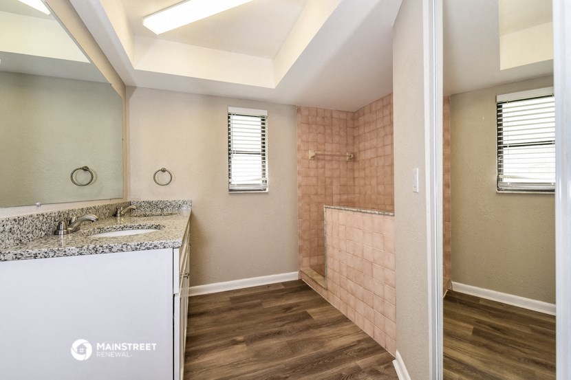 a bathroom with a shower and a sink and a mirror