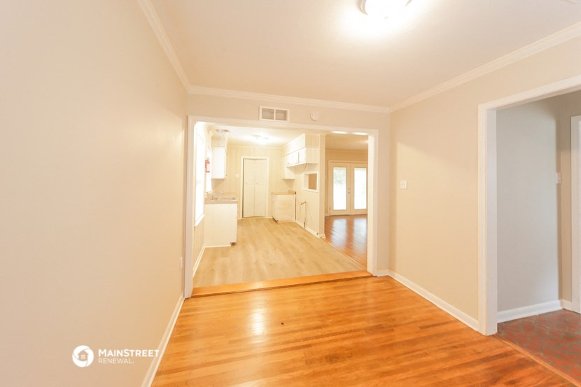 a renovated living room and dining room with a wood floor