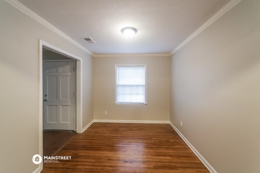 an empty room with a white door and a window