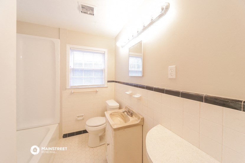 a white bathroom with a toilet and a sink