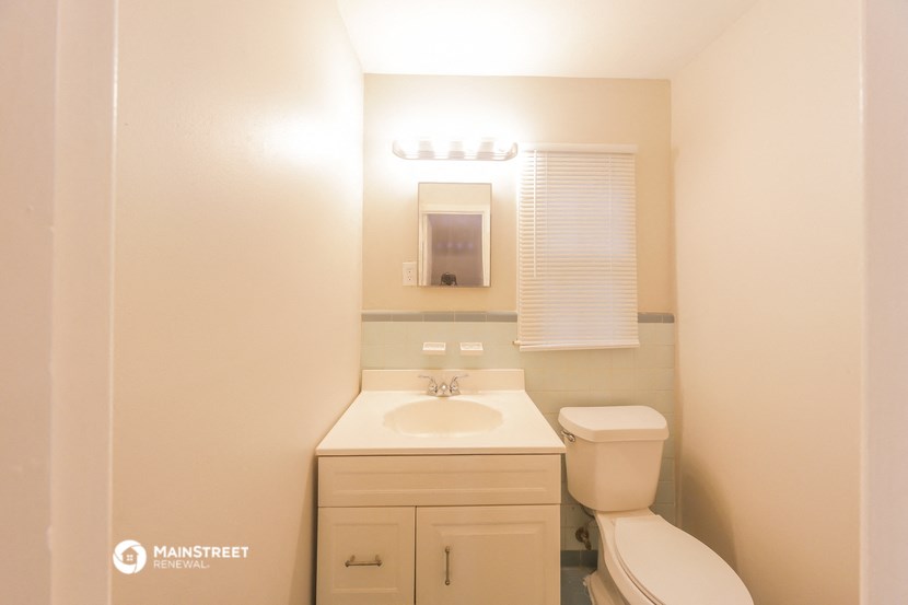 a bathroom with a toilet and a sink and a mirror