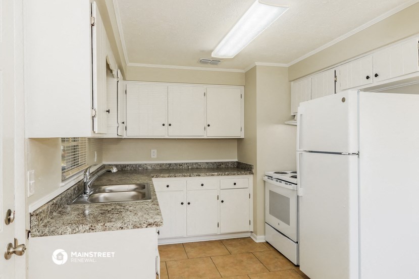 a kitchen with white appliances and white cabinets and granite counter tops