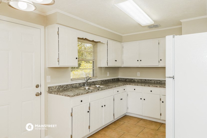 a white kitchen with white cabinets and granite counter tops