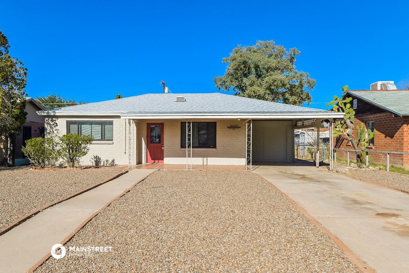 a white house with a gravel driveway and a porch