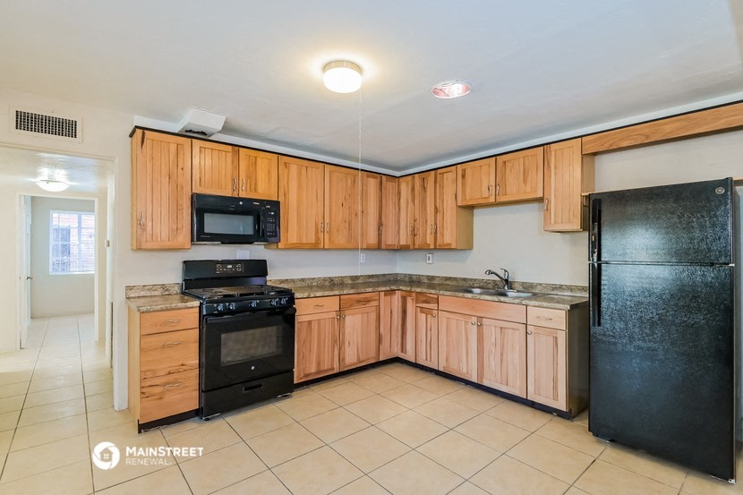 a large kitchen with black appliances and wooden cabinets