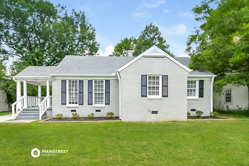 a white house with black shutters and a green lawn