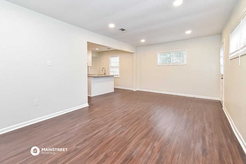the living room and kitchen of a new home with wood flooring