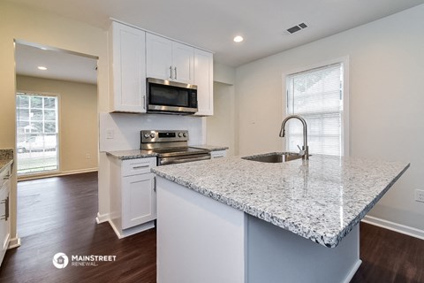 a kitchen with white cabinets and a granite counter top