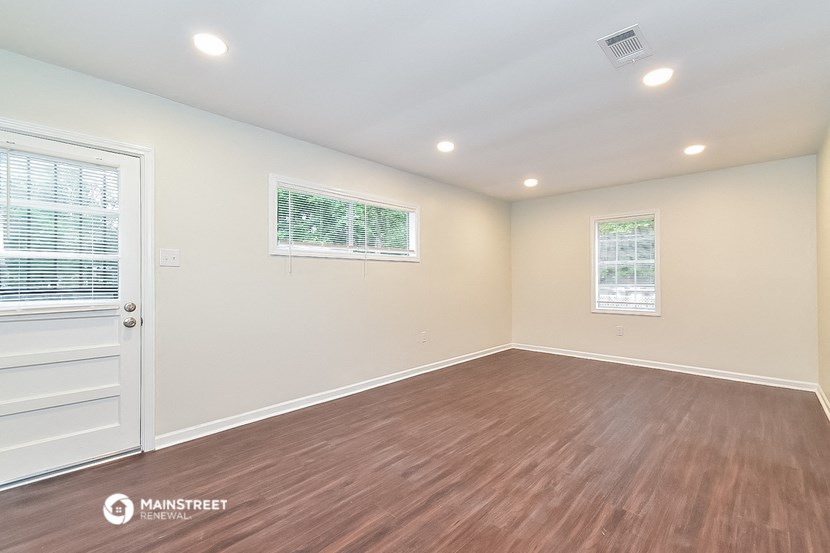the living room has a hardwood floor and a door to the kitchen