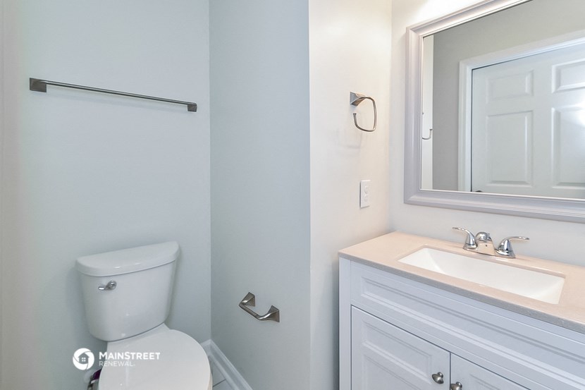 a bathroom with a toilet and a sink and a mirror